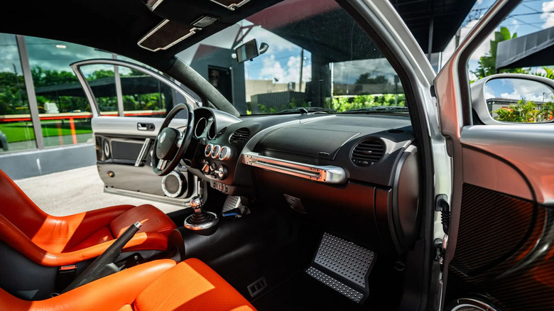 a look through the passenger door at the flawless and beautiful interior of the Beetle RSi with its orange seats and exposed carbon and aluminum trim
