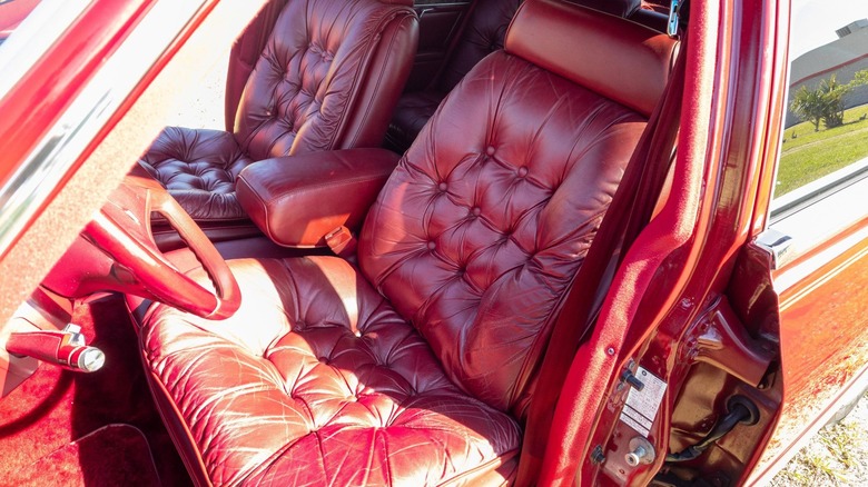 A photo looking in the driver's door of the fifth avenue showing the red tufted leather seats