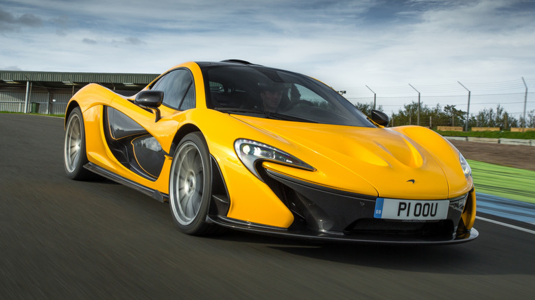 Front 3/4 view of a yellow McLaren P1 on track.