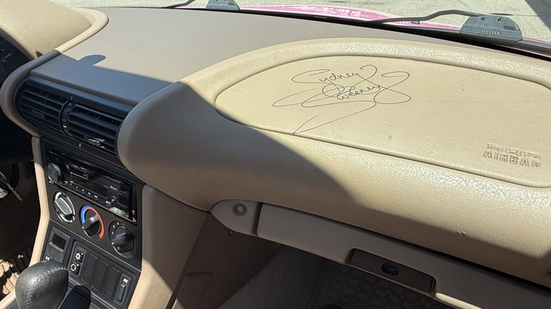 Sydney Sweeney's signature on the airbag cover on the tan dashboard of the 2007 BMW Z3 Roadster