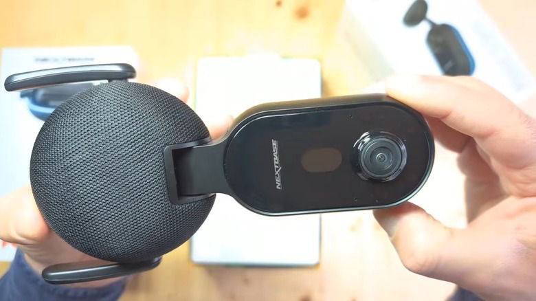 A person unboxing and holding a Nextbase iQ 2K dashcam