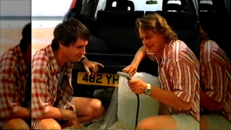 Screenshot of a TV commercial showing two men using the Honda CR-V's shower attachment