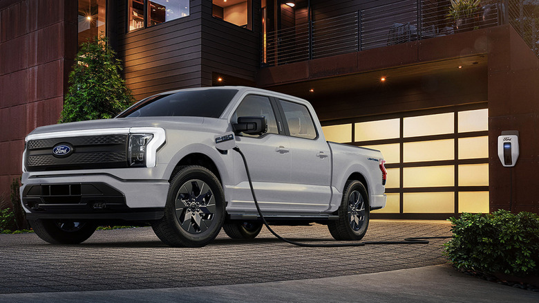 A white 2024 Ford F-150 Lightning charging at home.