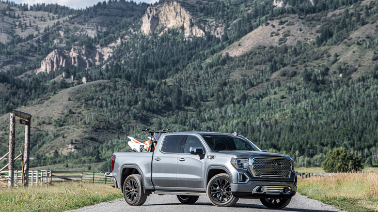A gray 2021 GMC Sierra 1500 parked in front of a mountain.