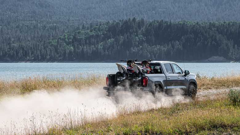 A gray 2021 GMC Sierra 1500 traveling on an unpaved trail.