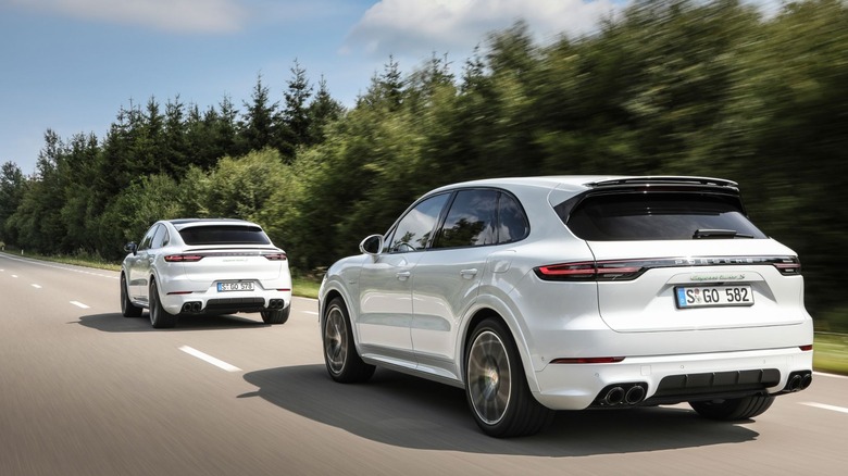Two white Porsche Cayenne Turbo S E-Hybrid models driving on the road
