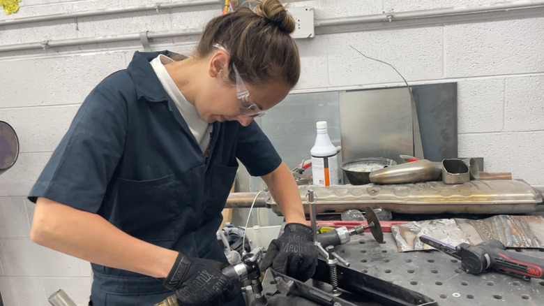 The writer, Lalita Chemello (me), working on a piece of the dashboard for the Girl Gang Garage Volvo project Iron Maven in 2022.
