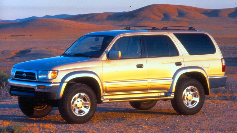 front three-quarters shot of a silver third-gen 4Runner parked on dirt in front of rolling desert hills