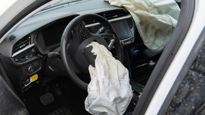 A photo of a car's interior with the driver and passenger-side airbags deployed