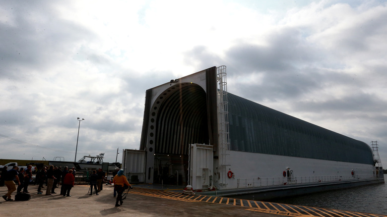 A front-and-side view of the NASA Pegasus barge docked at a harbor