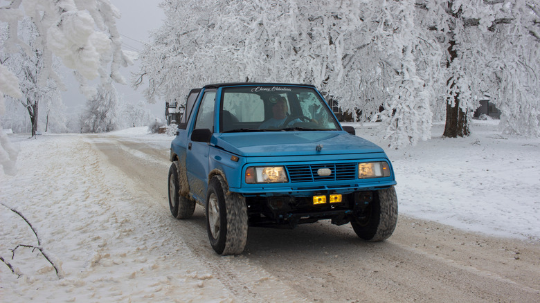 A blue Geo Tracker driving in the snow