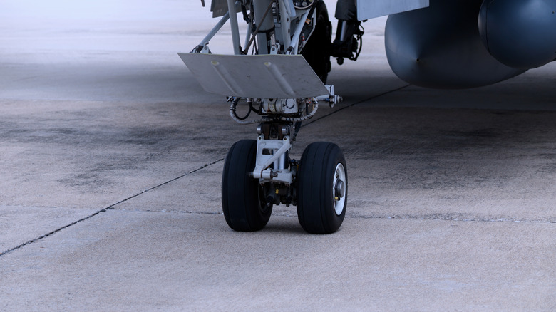 a jet's landing gear on pavement