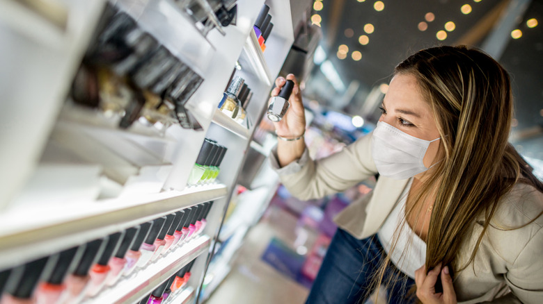 A woman buying nail polish in an airport.
