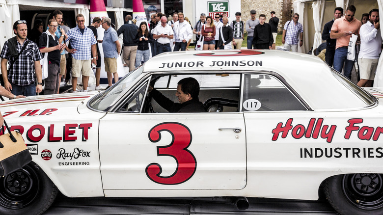 NASCAR legend Junior Johnson's white number 3 1963 Chevrolet Impala with the 427 Mystery Motor surrounded by a crowd of onlookers