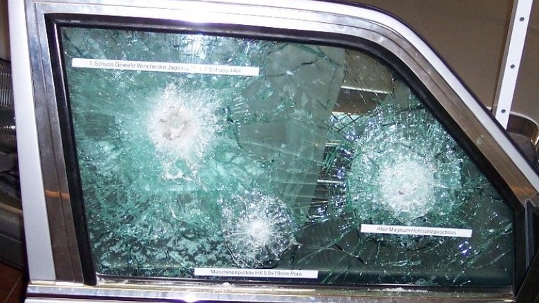 A car window of bulletproof glass that has taken multiple gunshot impacts without being penetrated