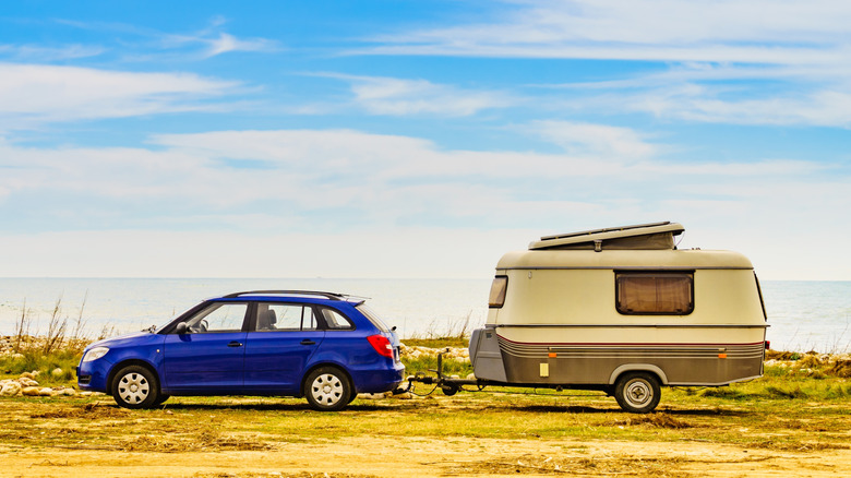 Side shot of a blue Skoda Fabia Estate towing a caravan