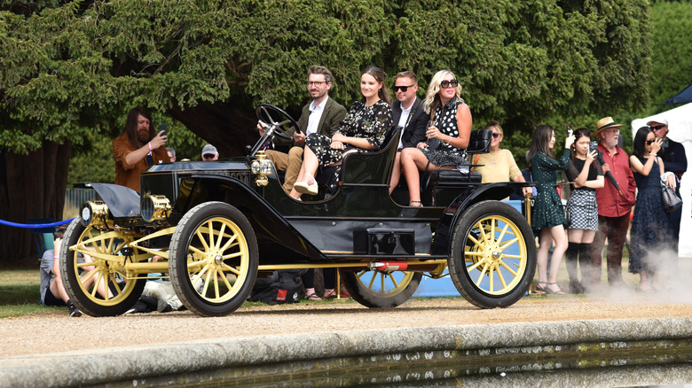 A Stanley Steamer being driven at a car show