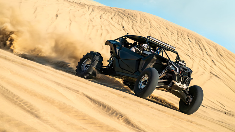 A sand rail driving on a dune