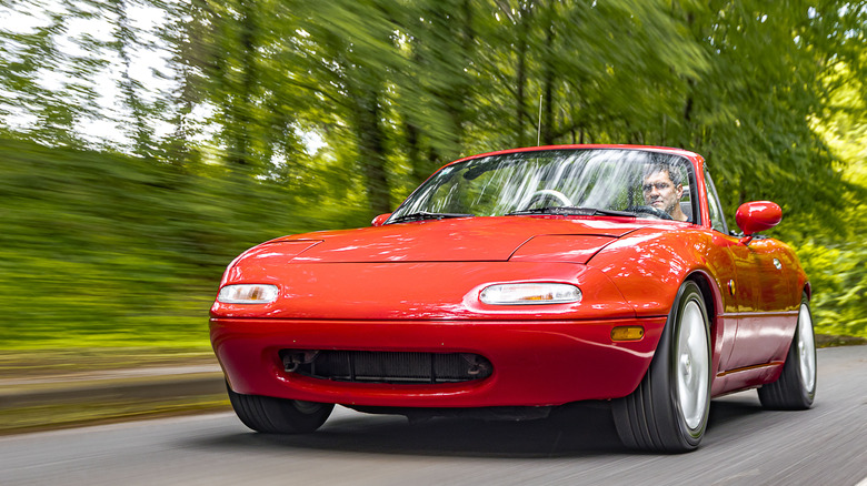 Red Mazda Miata driving on a good road