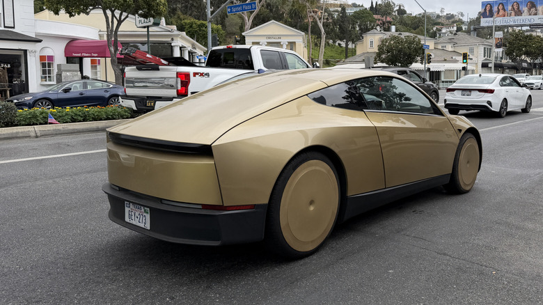 Rear 3/4 view of a gold Tesla Cybercab