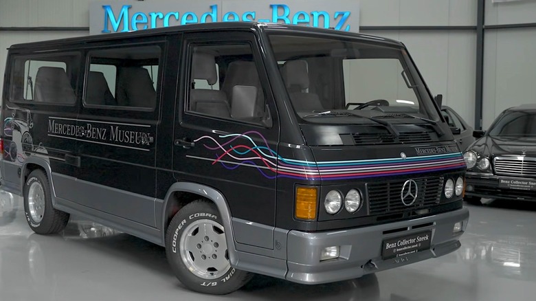 A Mercedes-Benz 100 D AMG sitting in a museum collection, featuring neat graphics and clean two-tone paint.