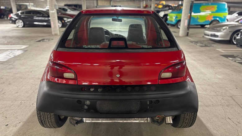 Rear view of a red Geo Metro with a mid-engine V8 swap and a perforated rear bumper for cooling