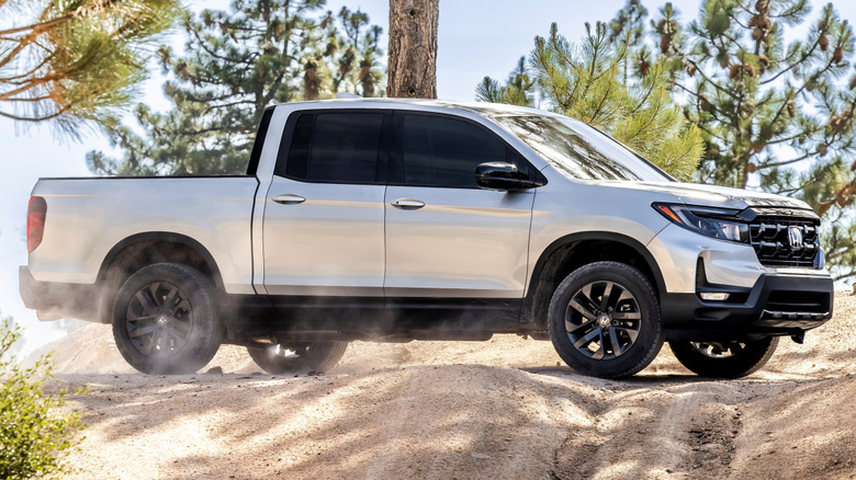 The side profile of a 2026 Honda Ridgeline driving on sand