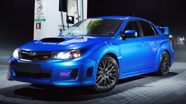 A Subaru WRX STi parked at a gas station.