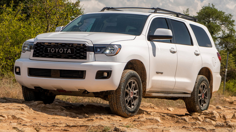 A 3/4 front view of a white 2020 Toyota Sequoia driving off-road