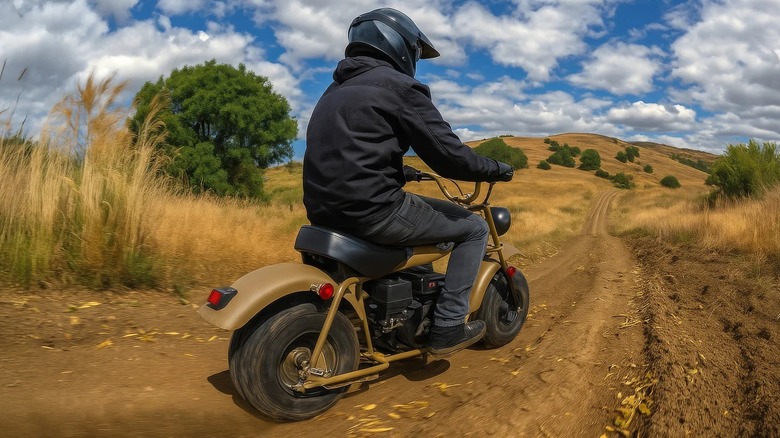 A Massimo MB 200 mini bike riding away down a dirt trail