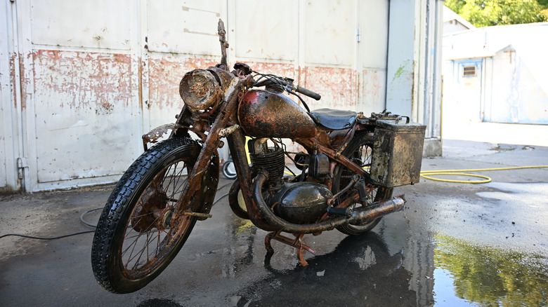 A cleaned up, old wartime bike, still wet from washing in a well-lit garage area.