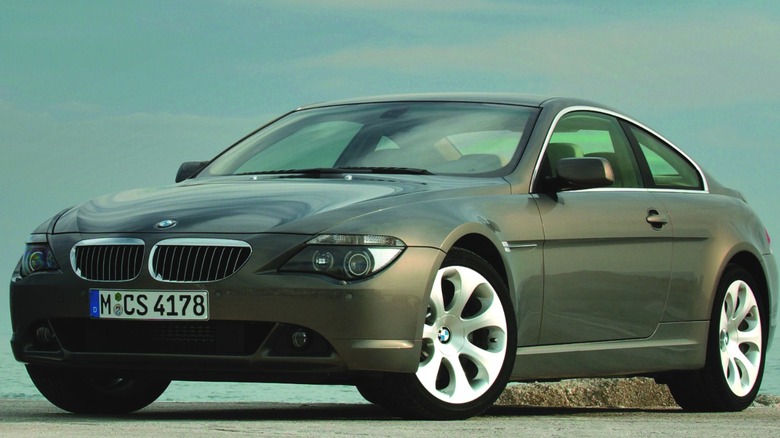front three-quarters shot of a metallic sand-colored BMW 645 parked in front of rocks and a blue sky