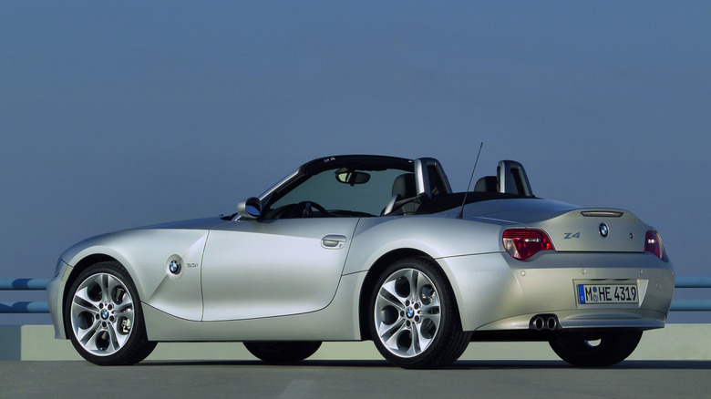 rear three-quarters shot of a silver LCI Z4 parked with its top down in front of a blue sky