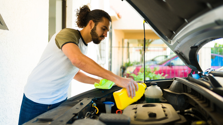 A man changing the engine oil of his car