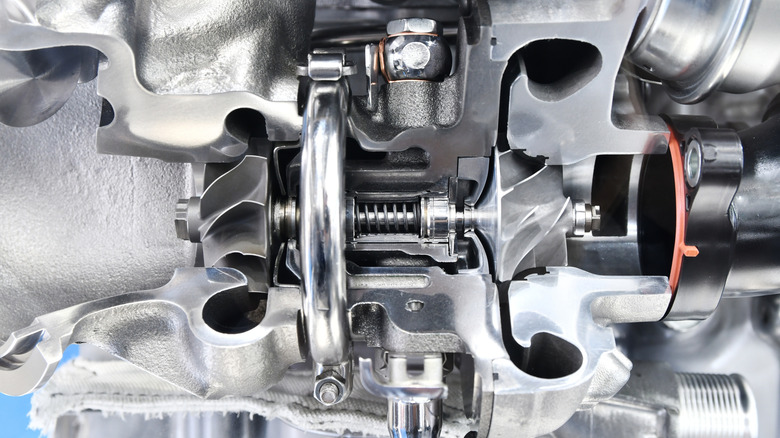 A cutaway of a turbocharger showing its intake and exhaust sides.