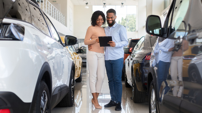 Two people at a dealership looking at a clipboard
