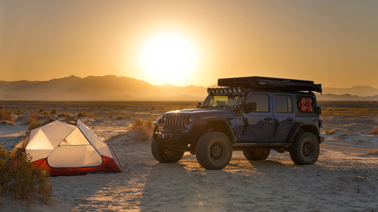 Jeep Wrangler parked in Mojave Desert next to tent