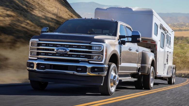 A Ford F-350 Super Duty hauling a large trailer uphill.