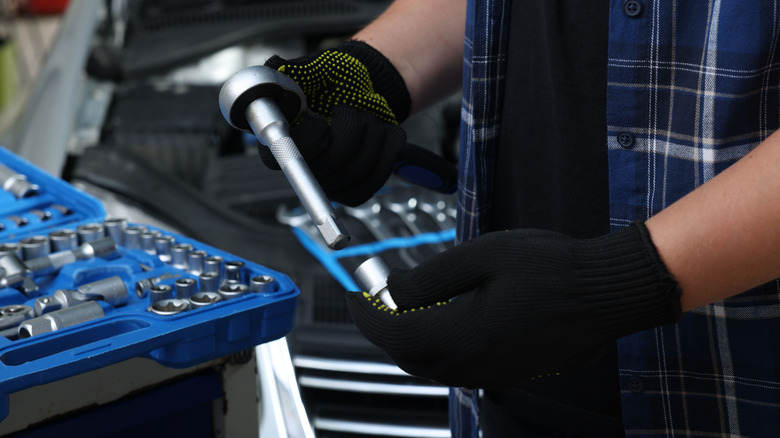 A person holding torque wrench with extension