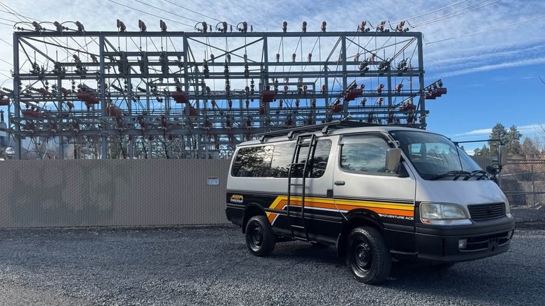 A silver and black van with yellow and orange stripes