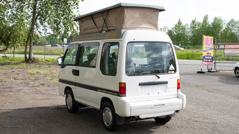 A white small van with a pop top camper