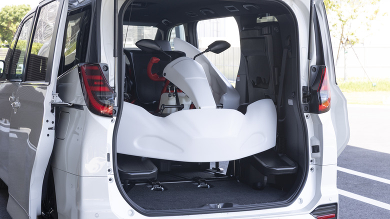 A white Toyota GR Kart inside the back of a white Toyota Noah