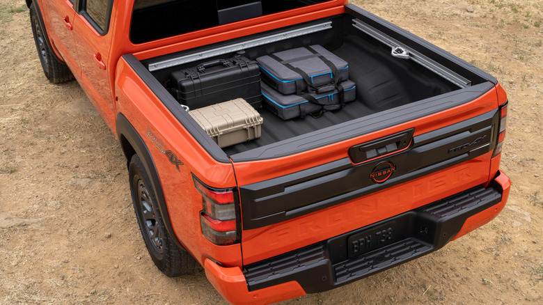 Looking down into the open cargo bed of an orange Nissan Frontier PRO-4X pickup truck.