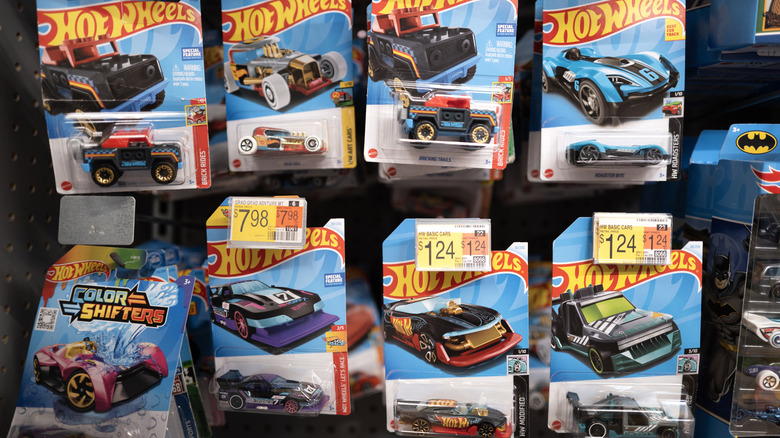 Hot Wheels cars hanging on pegs, for sale in a store