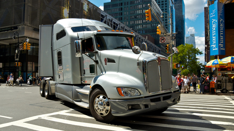 A big tractor-trailer turning from W. 42nd Street onto 8th Avenue in New York.