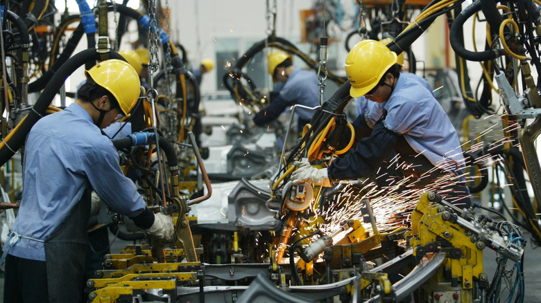HAIKOU, CHINA - APRIL 6: (CHINA OUT) Employees on the assembly line produce cars in Mazda's "Family" line of vehicles at China First Automobile Works (FAW) Group Haima Automobile Co., Ltd. April 6, 2005 in Haikou, Hainan Province, China. China has become the world's third largest automotive market with 2004 car sales in the country growing 15.17 percent to 2.33 million units, even though curbs on credit reduced demand. The market began slowing by mid-2004, affected by the government's measures to cool a fast-expanding economy. Analysts expect car sales in China to increase in 2005 by 10 percent. (Photo by China Photos/Getty Images)