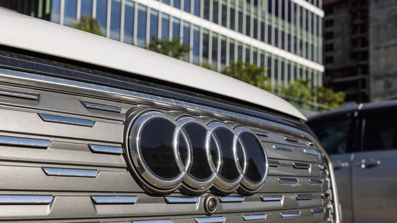 Close-up of the Audi rings emblem on the front grille of a white Audi Q4 e-tron