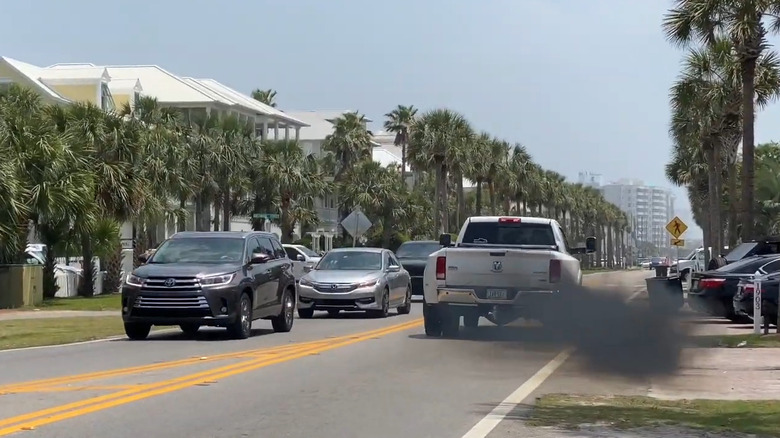 A white Dodge Ram rolls coal