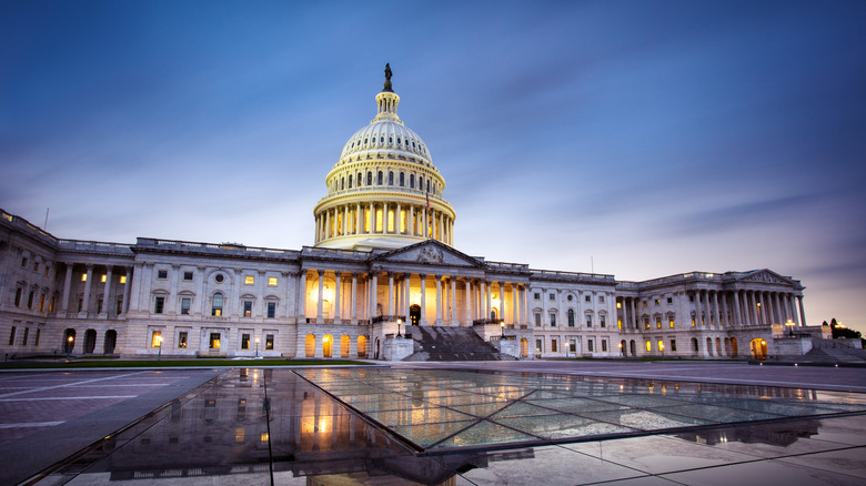 The U.S. Capitol building illuminated at twilight under dark clouds