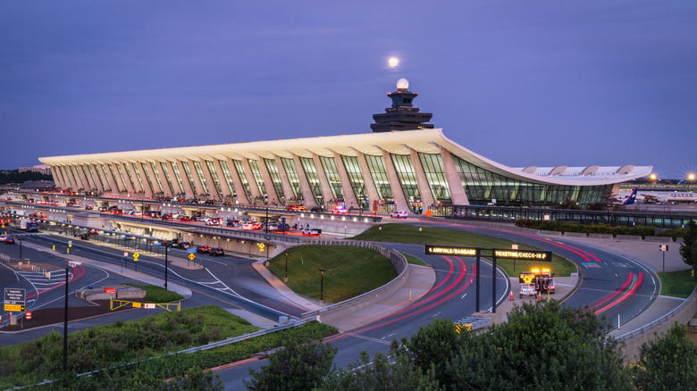Traffic flows past the main passenger terminal at Washington Dulles International Airport at dusk on May 11, 2025, in Dulles, VA.